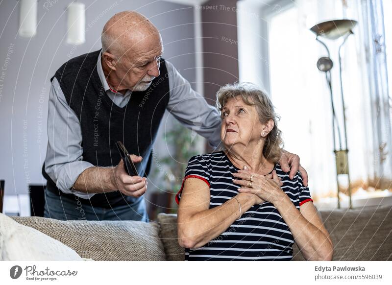 Ältere Frau leidet unter Brustschmerzen, während ihr Mann sie tröstet echte Menschen Senior reif männlich Paar Zusammensein Kaukasier älter heimwärts Haus alt
