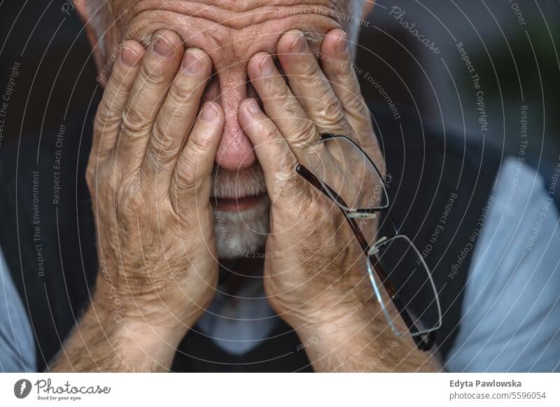 Depressiver älterer Mann bedeckt sein Gesicht mit beiden Händen echte Menschen Senior älterer Erwachsener reif männlich Kaukasier heimwärts Haus alt Alterung