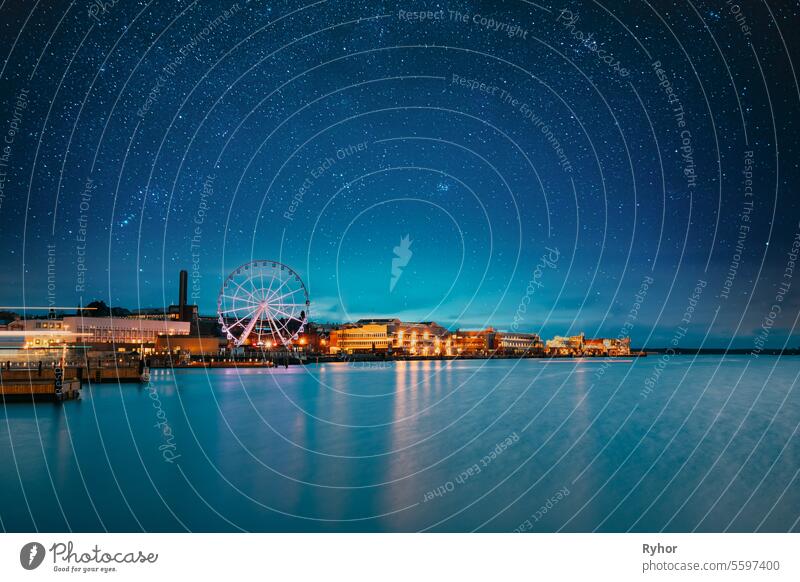 Helsinki, Finnland. Bright Blue Starry Sky Above Embankment With Ferris Wheel In Evening Night Illuminationen. Hellblauer dramatischer Himmel Blaue Stunde MEER
