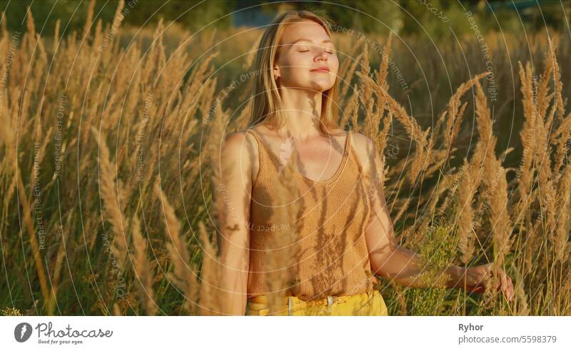 Porträt der jungen hübschen kaukasischen glückliches Mädchen Frau verwenden Atmung Programme im Sommer Wiese. Gesunder Lebensstil Konzept. Einheit mit der Natur. Yoga Konzept Lebensstil. Ruhe und Gelassenheit