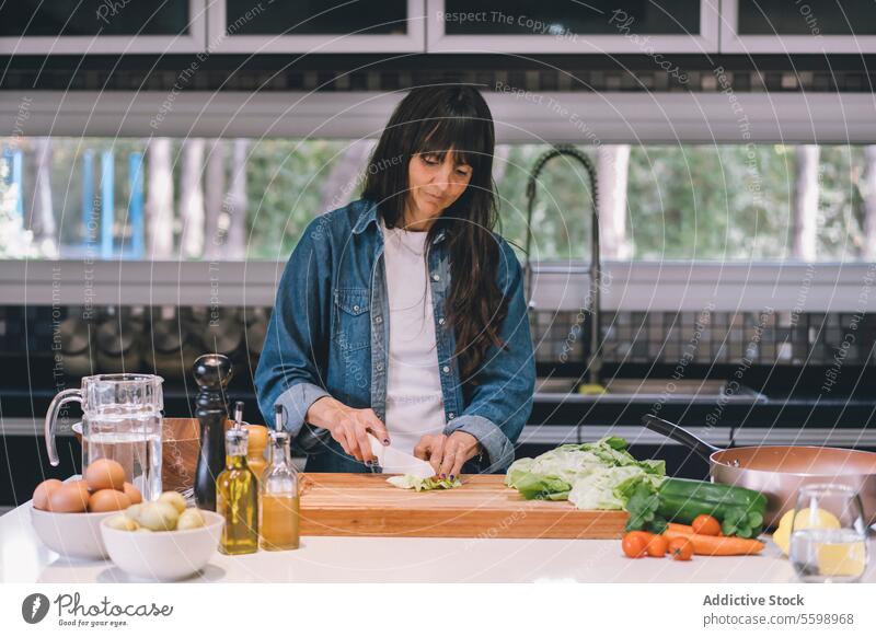 Mittlere erwachsene Frau, Hausfrau, bereitet frischen Salat zu Avocado Schalen & Schüsseln Küchenchef hacken zerkleinernd Essen zubereiten ausschneiden
