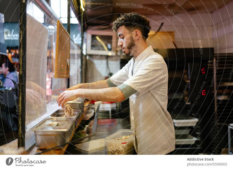 Pizzamann füllt Zutaten in Behälter arabisch Bäcker Pilze Brot Bäckerei Vorbereitung Teigwaren frisch arbeiten Skala Gewichtung Schulterblatt Herstellung Mehl
