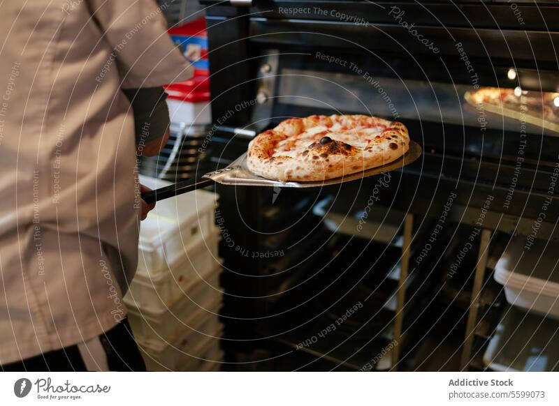 Pizza auf einer Schaufel frisch aus dem Ofen unkenntlich Mann Lebensmittel Italienisch Restaurant schaufeln Abendessen neapolitanisch Käse traditionell Mahlzeit