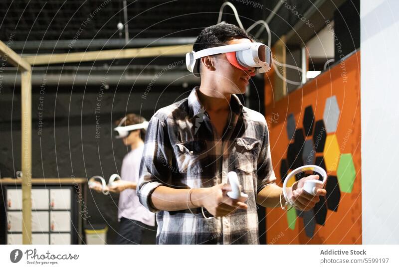Seitenansicht eines jungen, aufgeregten Mannes, der mit einem VR-Headset und Controllern ein Virtual-Reality-Spiel spielt Virtuelle Realität