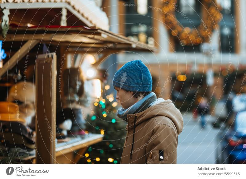 Mann beim Einkaufen an einem Weihnachtsmarktstand in Quebec, Kanada Verkaufswagen Winter im Freien festlich Dekoration & Verzierung Beanie Mantel Feiertag