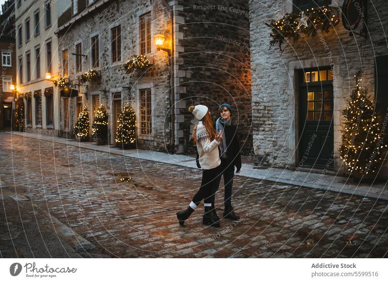 Ein Paar genießt eine festliche Weihnachts-Straßenszene in Quebec, Kanada Weihnachten Feiertag Baum Dekoration & Verzierung Licht romantisch Spaziergang