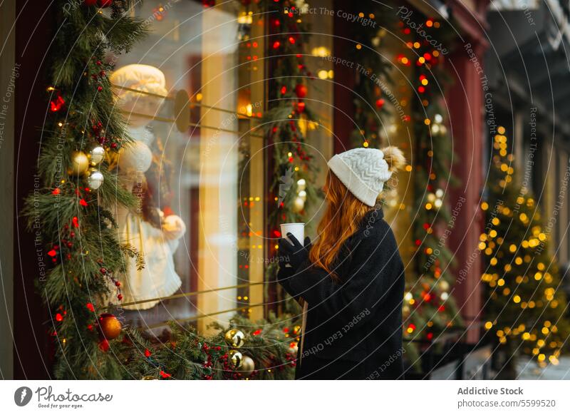 Frau bewundert Schaufensterauslage im Winter in Quebec, Kanada Kaffee Weihnachten Feiertag Fenster Anzeige Becher Dekoration & Verzierung Licht festlich