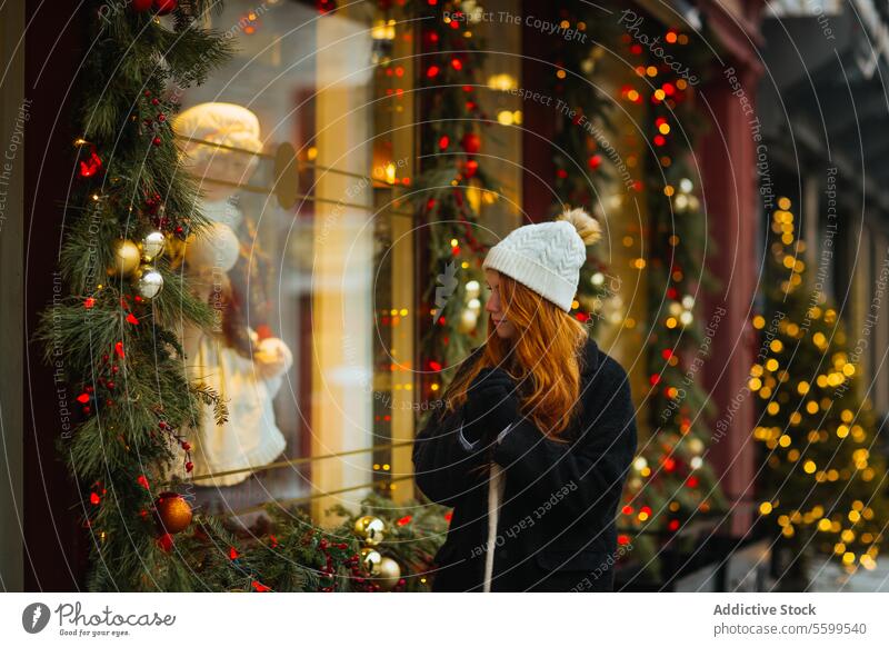 Frau bewundert Schaufensterauslage im Winter in Quebec, Kanada Feiertag Fenster Anzeige Weihnachten Lichter Dekorationen gemütlich Hut Mantel festlich
