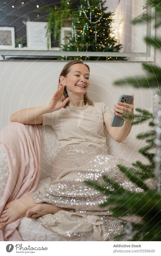 Frau entspannt sich zu Hause während der Festtage Weihnachten entspannend heimwärts Sofa Lächeln abgelegen Baum festlich Saison räkeln bequem friedlich Moment