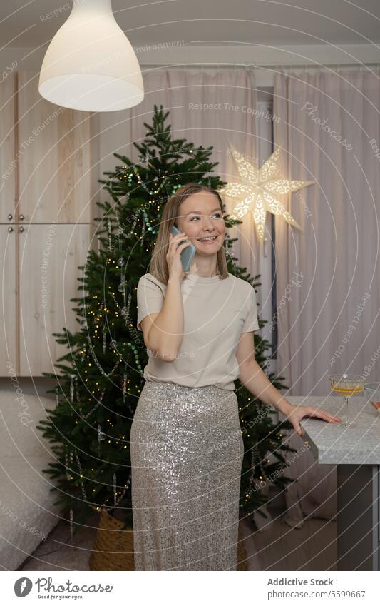 Frau genießt ein festliches Getränk unter einem Weihnachtsbaum Weihnachten Baum trinken Lächeln Dekoration & Verzierung gemütlich Feiertag Ornament Licht