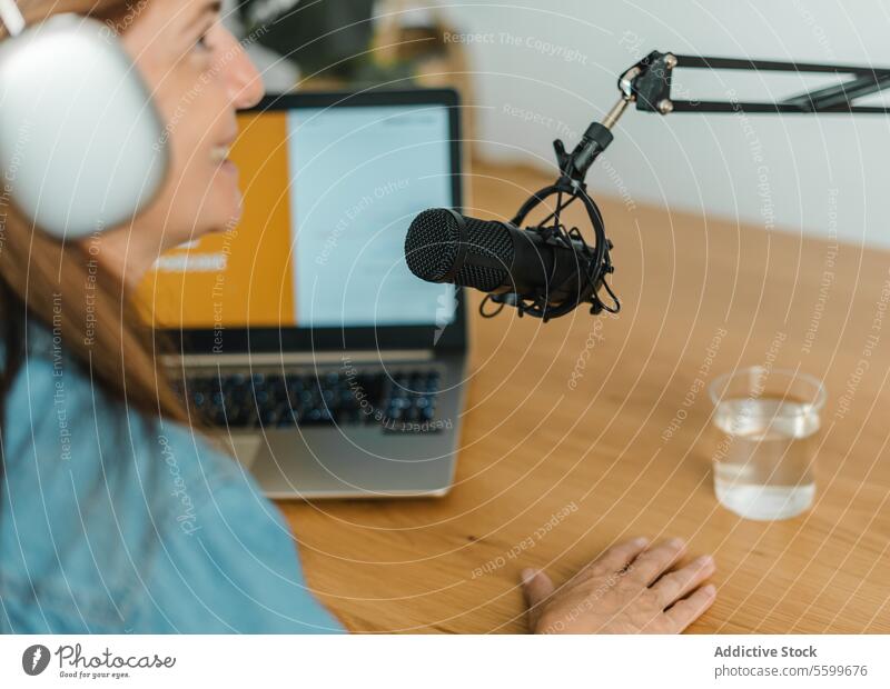 Frau nimmt Podcast am Tisch mit Mikrofon auf Aufzeichnen reden modern Radio Wirt sprechen Laptop Ausstrahlung Arbeit Atelier Kopfhörer Gerät Kommunizieren