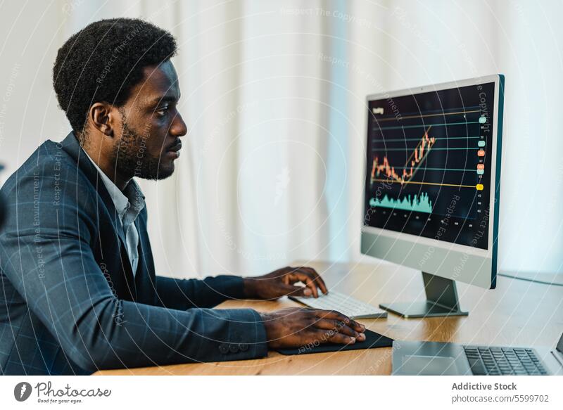 Konzentrierter schwarzer Mann beim Online-Handel mit binären Optionen Händler Tabelle Statistik analysieren Makler online männlich Investition Afroamerikaner