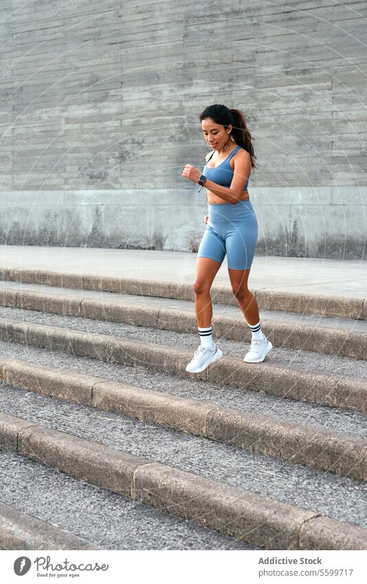 Aktive lateinamerikanische Frau beim Joggen auf der Treppe Lateinamerikaner Training Sportbekleidung aktiv Fitness Übung im Freien fokussiert Gesundheit