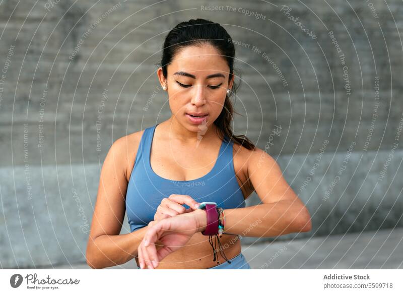 Lateinamerikanerin verfolgt Fitnessfortschritt mit Smartwatch Frau smartwatch Training Gesundheit überwachen Übung Sportbekleidung Athlet Technik & Technologie