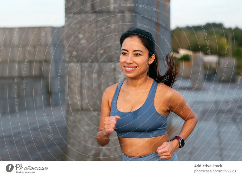 Fröhliche lateinamerikanische Frau genießt Lauftraining im Freien Lateinamerikaner rennen aktiv Lifestyle Übung Fitness Lächeln Training Kleidung Positivität