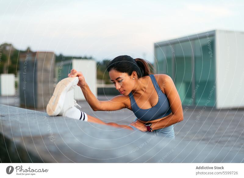 Aktive lateinamerikanische Frau beim Dehnen im Freien Lateinamerikaner strecken Fitness Sportkleidung Training trainiert. Gesundheit Wohlbefinden Lifestyle jung