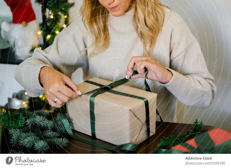 Frau packt Weihnachtsgeschenk zu Hause ein horizontal Bändchen professionell Person Objekte Veranstaltung Papier dekorierend im Innenbereich Überraschung