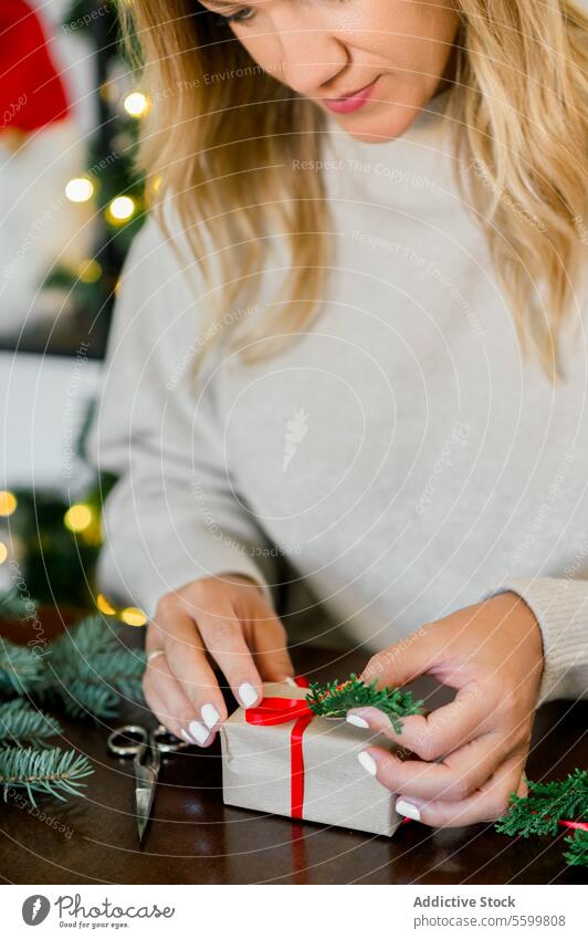 Frau packt schönes Weihnachtsgeschenk am Tisch ein Weihnachten Person Feier präsentieren Verpackung Feiertag Hand Kasten Überraschung rot festlich Bändchen