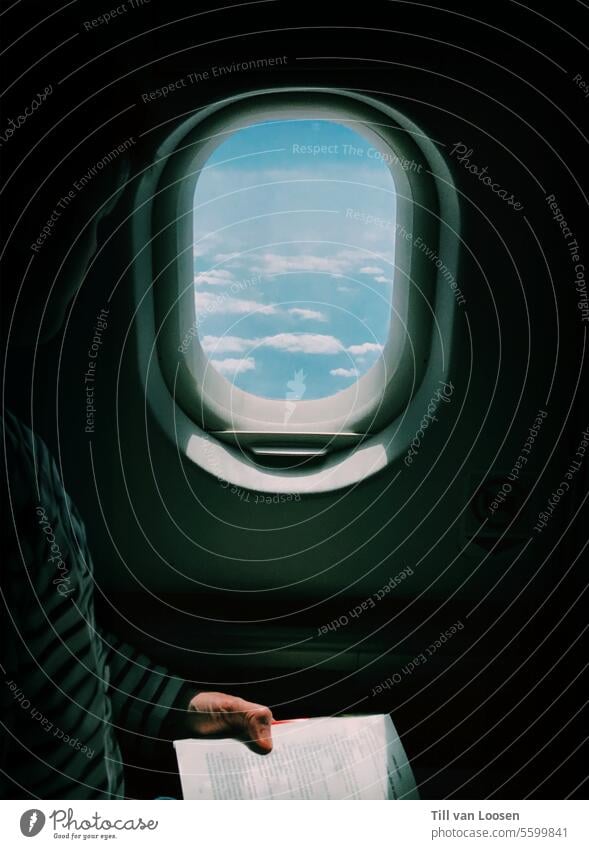 Flugzeugfenster Fenster Buch lesen Wolken Kontrast hell und dunkel Daumen Himmel Luftverkehr Ferien & Urlaub & Reisen fliegen blau Flugzeugausblick Tourismus