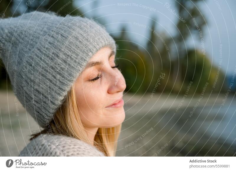 Eine junge Frau atmet saubere Luft, schaut mit einem Lächeln und geschlossenen Augen in den Himmel Person Gesicht Porträt Kaukasier Model Sonne zugeklappt