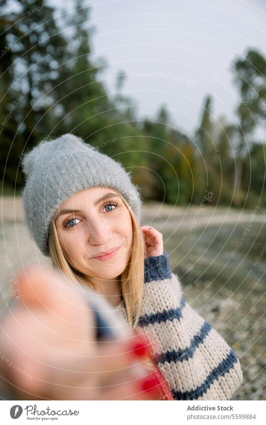 Lächelnde Frau nimmt Selfie gestrickt Landschaft Stil Pullover trendy Hut warm Natur jung Dame Glück heiter Vorschein Freude lässig modern in die Kamera schauen