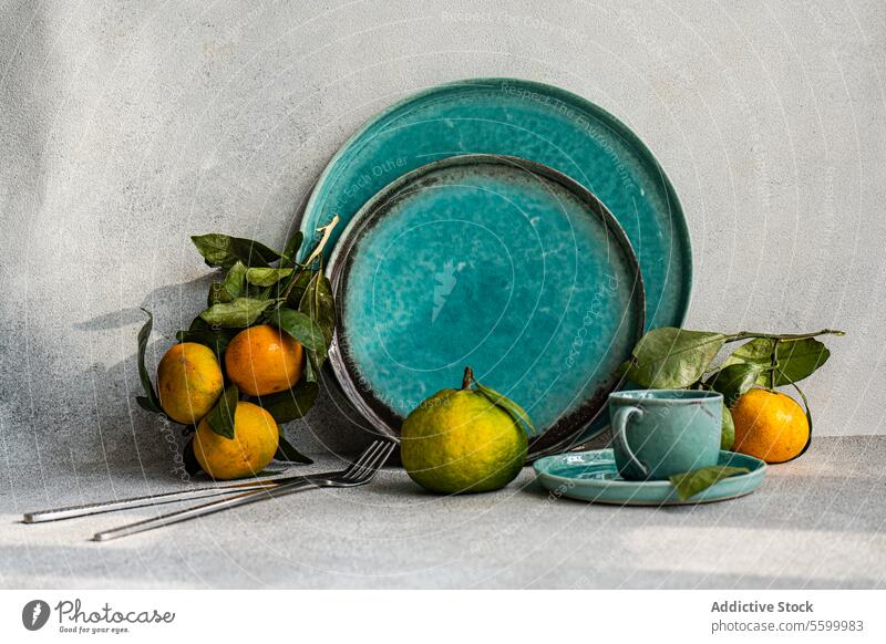 Türkisfarbener gedeckter Tisch mit Zitrusfrüchten türkis Tabelleneinstellung frisch Frucht speisend Atmosphäre Geschirr Keramik einladend Dekor Stil heimwärts
