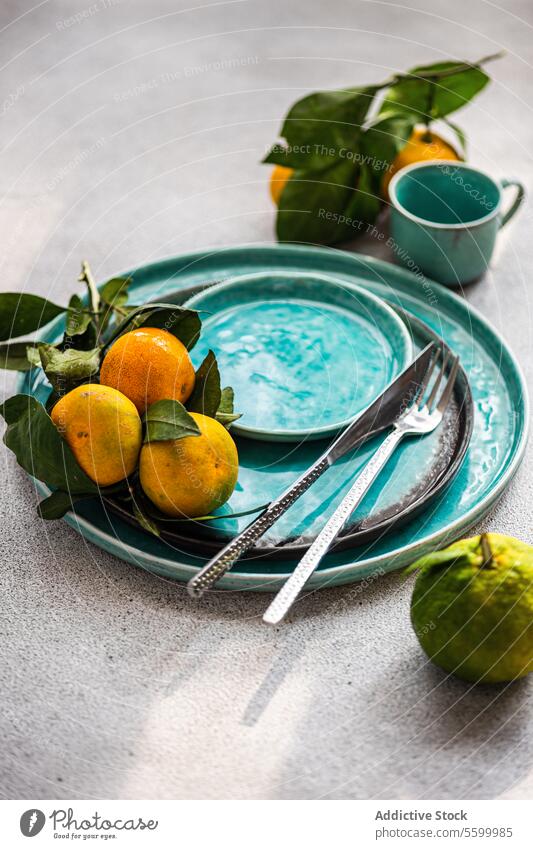 Zitrus-Eleganz auf Aqua-Teller Zitrusfrüchte aqua reif Zusammensetzung natürlich Frische Mandarine Keramik Frucht Blatt Geschirr texturiert Feinschmecker