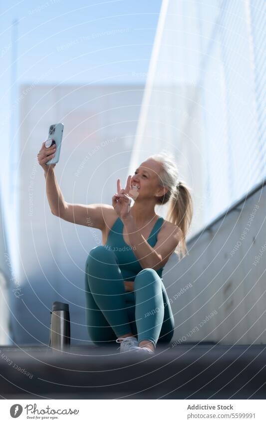 Aktive ältere Frau macht ein Selfie während einer Trainingspause aktiv reif Übung im Freien Senior Gesundheit Technik & Technologie passen Sport Kleidung heiter