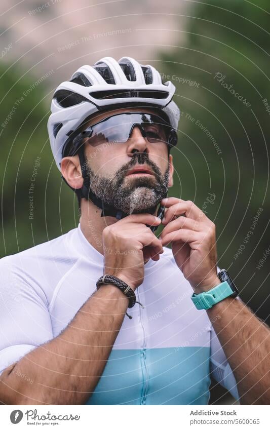 Radfahrer passt Helm an Mann Schutzhelm Sonnenbrille Anpassung Berge u. Gebirge Trikot weiß blau Porträt im Freien Sport Ausrüstung Sicherheit männlich