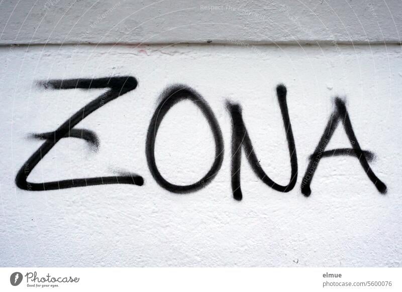 ZONA steht in schwarz an einer grauen Wand Zona Graffiti Zone Abgrenzung Areal Schmiererei Wandmalereien sprayen Jugendkultur Lifestyle Gürtelrose Blog