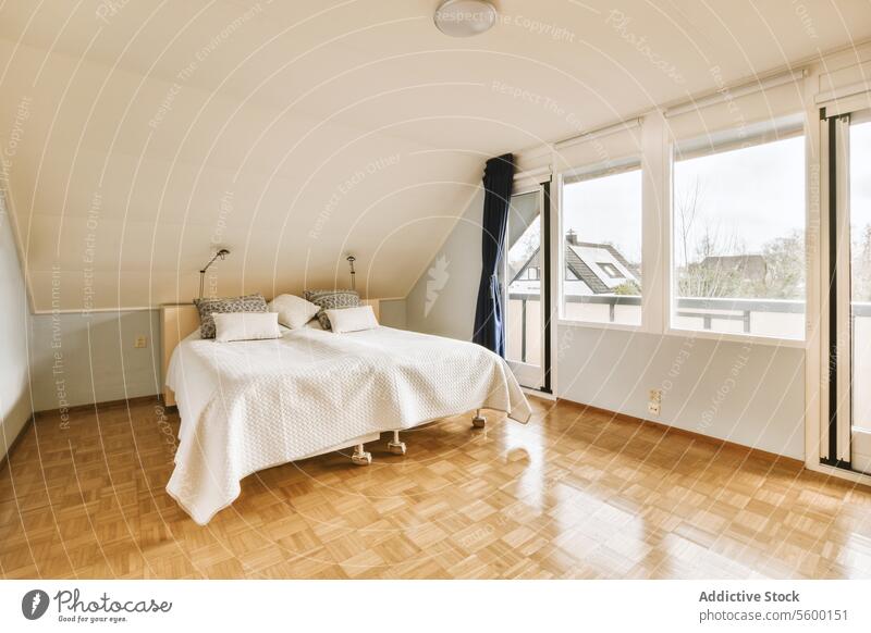 Schlafzimmer mit einem Bett und großem Fenster Kissen Zimmerdecke Stock Tür Gardine Lampe bequem geräumig modern gemütlich heimwärts Raum Innenbereich Möbel