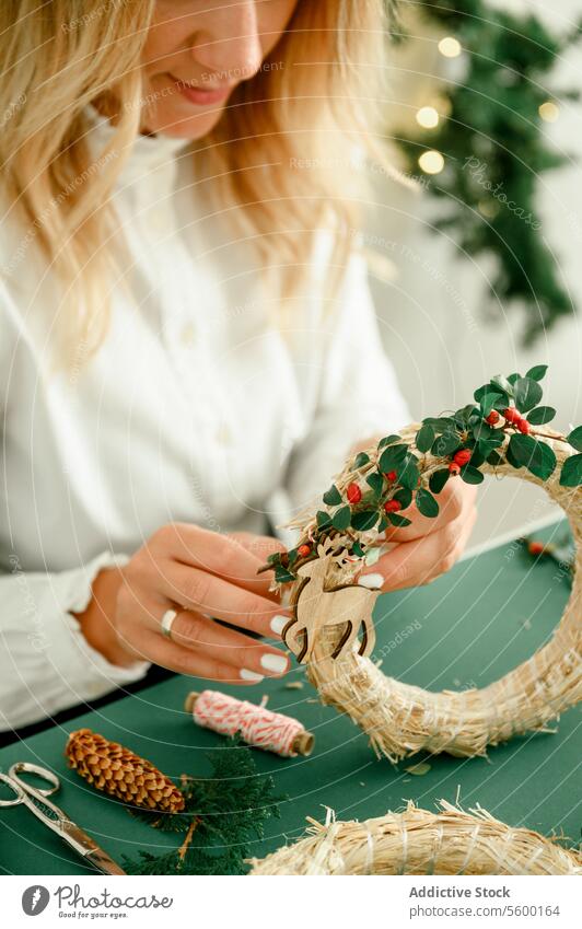Eine Frau bastelt einen Kranz für Weihnachten. Natürliche natürliche Dekoration, DIY, traditionelle Weihnachtsfeier. Anlass präsentieren von oben Veranstaltung