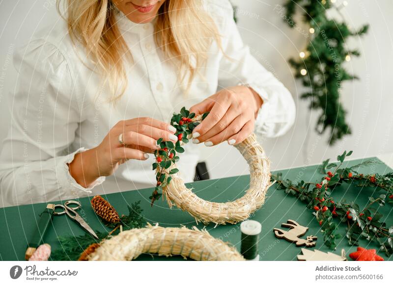 Frau beim Schmücken des Weihnachtskranzes zu Hause Anlass unkenntlich funkeln Zauberei u. Magie Atmosphäre präsentieren Ornament glänzend festlich von oben