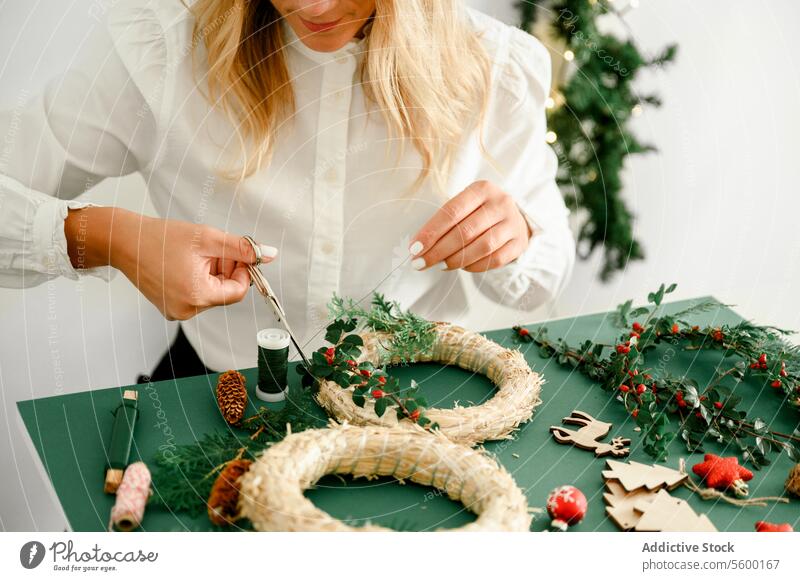 Frau beim Schmücken des Weihnachtskranzes zu Hause Anlass unkenntlich funkeln Zauberei u. Magie Atmosphäre präsentieren Ornament glänzend festlich von oben
