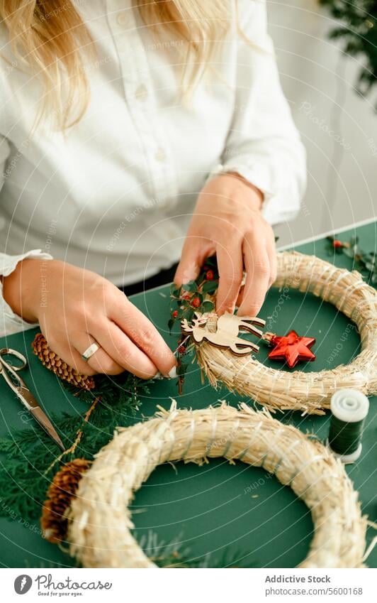 Frau beim Schmücken des Weihnachtskranzes zu Hause Weihnachten Totenkranz Kugel Tradition hängen festlich Ast Neujahr dekorieren Feiertag Inspiration fröhlich