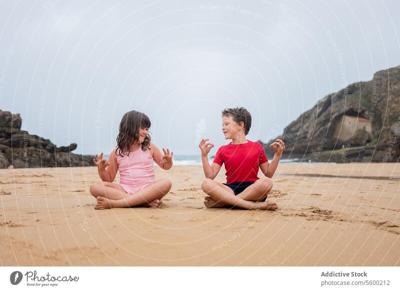 Spielerisches Strandtaggespräch zwischen zwei Kindern Gespräch spielerisch Sitzen Sand bedeckt Himmel Freund Kindheit Freude Freizeit im Freien Natur Küste
