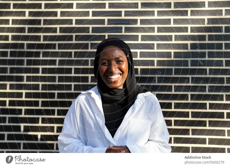 Glückliche muslimische Geschäftsfrau in der Stadt stehend Hijab Lächeln Unternehmer selbstbewusst schwarz Großstadt Frau positiv Tradition Outfit Kultur