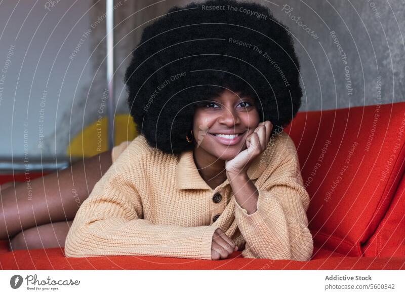 Sinnliche schwarze Frau auf Sofa liegend Vorschein Afro-Look Make-up sinnlich ruhen sich[Akk] entspannen attraktiv Liege Afroamerikaner jung Komfort Frisur