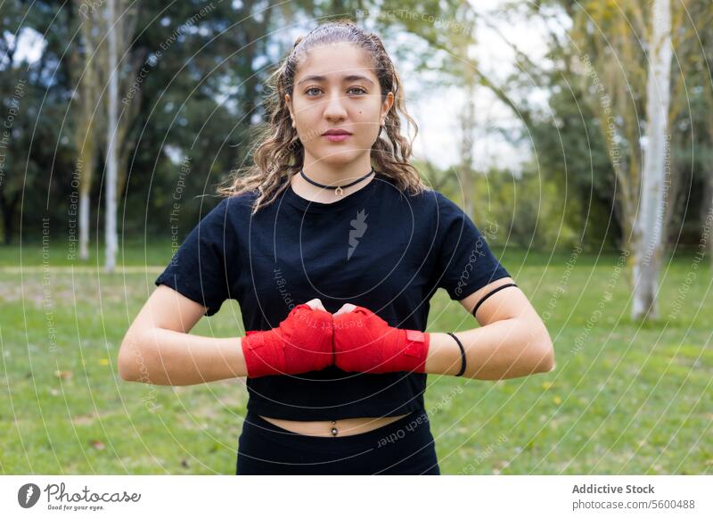 Boxer Frau mit Händen rote Bandage wickeln für Boxen im Freien Erwachsener Kunst Athlet Hintergrund bandagieren schwarz Körper Boxsport Verteidigung Tatkraft