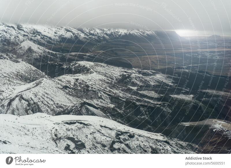 Luftaufnahme eines verschneiten Berghangs mit Tal Bergabhang Ansicht dramatisch Sonnenlicht getrübt Horizont Landschaft Natur Winter kalt im Freien riesig