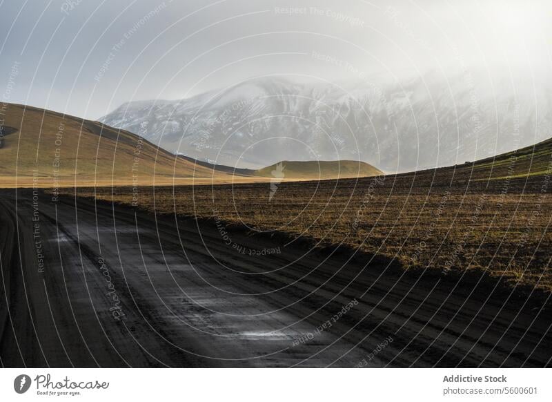 Gelassenes isländisches Hochland mit Schotterstraße Island Highlands Berge u. Gebirge Schnee Ruhe Landschaft Natur im Freien Gelassenheit Straße