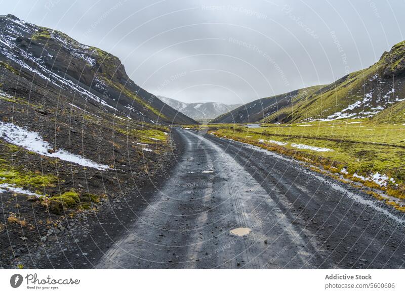 Abgelegene Schotterstraße durch isländisches Hochland Island Straße Kies Landschaft Natur desolat abgelegen robust Berge u. Gebirge Schnee Klippe malerisch