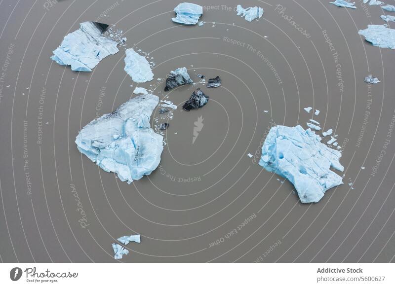 Eisfragmente in Gletschergewässern Chunk Felsbrocken schlammig Wasser glazial Schmelzwasser Vatnajökull Nationalpark Island Eisberg Sediment Schlamm braun blau