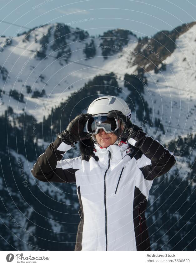 Skifahrer beim Einstellen der Skibrille in den Schweizer Alpen Berglandschaft Frau Schnee Berge u. Gebirge Schutzbrille Winter Sport Skikleidung weiß