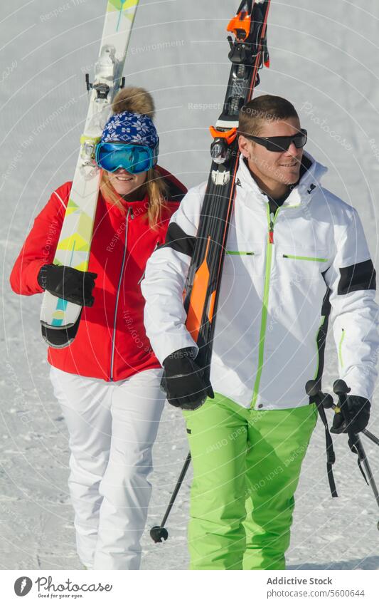 Ehepaar beim Wandern mit Skiausrüstung in den Schweizer Alpen Paar Winter Sport Schnee laufen sonnig Skikleidung farbenfroh Aktivität Berge u. Gebirge im Freien