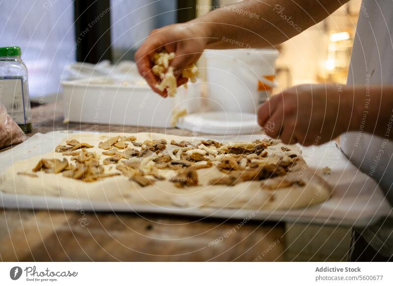Hände, die Zutaten auf die Pizza legen Nahaufnahme Bäcker Küche Lebensmittel Teigwaren Pilz Käse Focaccia Essen zubereiten jung Mehl Koch Person Rezept Tisch