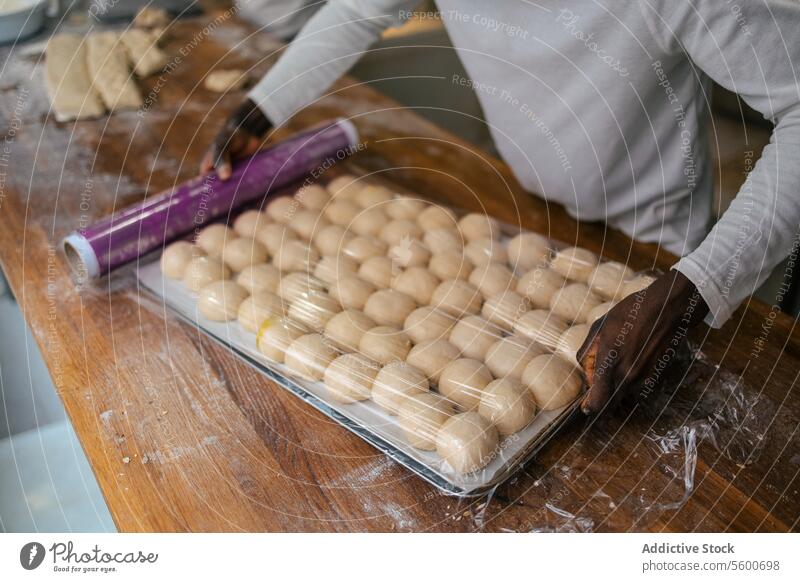 Porträt der Teigkugeln in der Schale Nahaufnahme Hände Heben Teigwaren Bälle Brot Bäckerei Tablett Lebensmittel Mehl Weizen frisch Hefe backen geschmackvoll