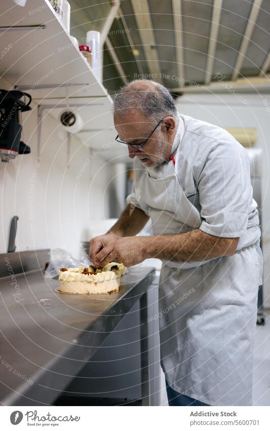 Konditorin beim Verzieren einer Torte Kuchen Küchenchef Mann Gebäck Dessert süß Lebensmittel Dekoration & Verzierung professionell geschmackvoll Sahne lecker