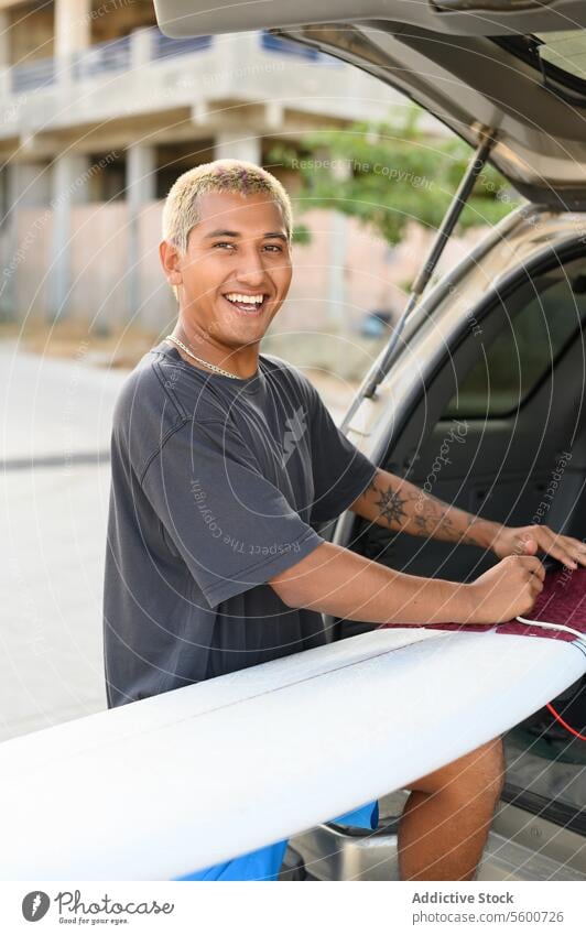 Glücklicher Mann mit Surfbrett im Auto auf der Straße PKW Automobil Fahrzeug männlich Verkehr Fahrer Lächeln selbstbewusst ethnisch Dienst heiter modern jung