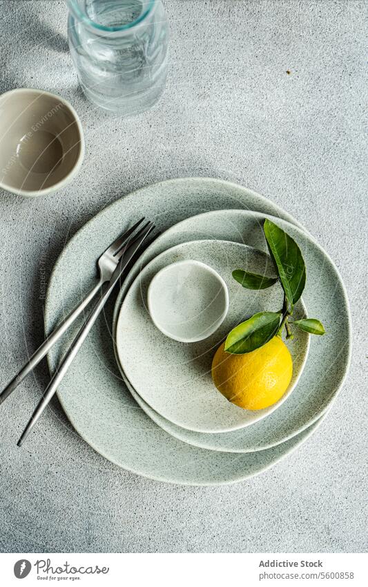 Frische Zitrone auf gesprenkeltem Keramikgeschirr frisch Blätter gefleckt Essgeschirr Besteck Glaswaren texturiert Oberfläche pulsierend Teller